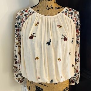 Free People cream colored top with floral embroidery.